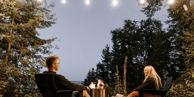 Couple enjoying renovated outdoor living space in Calgary with modern fire pit and patio lights, 2025.