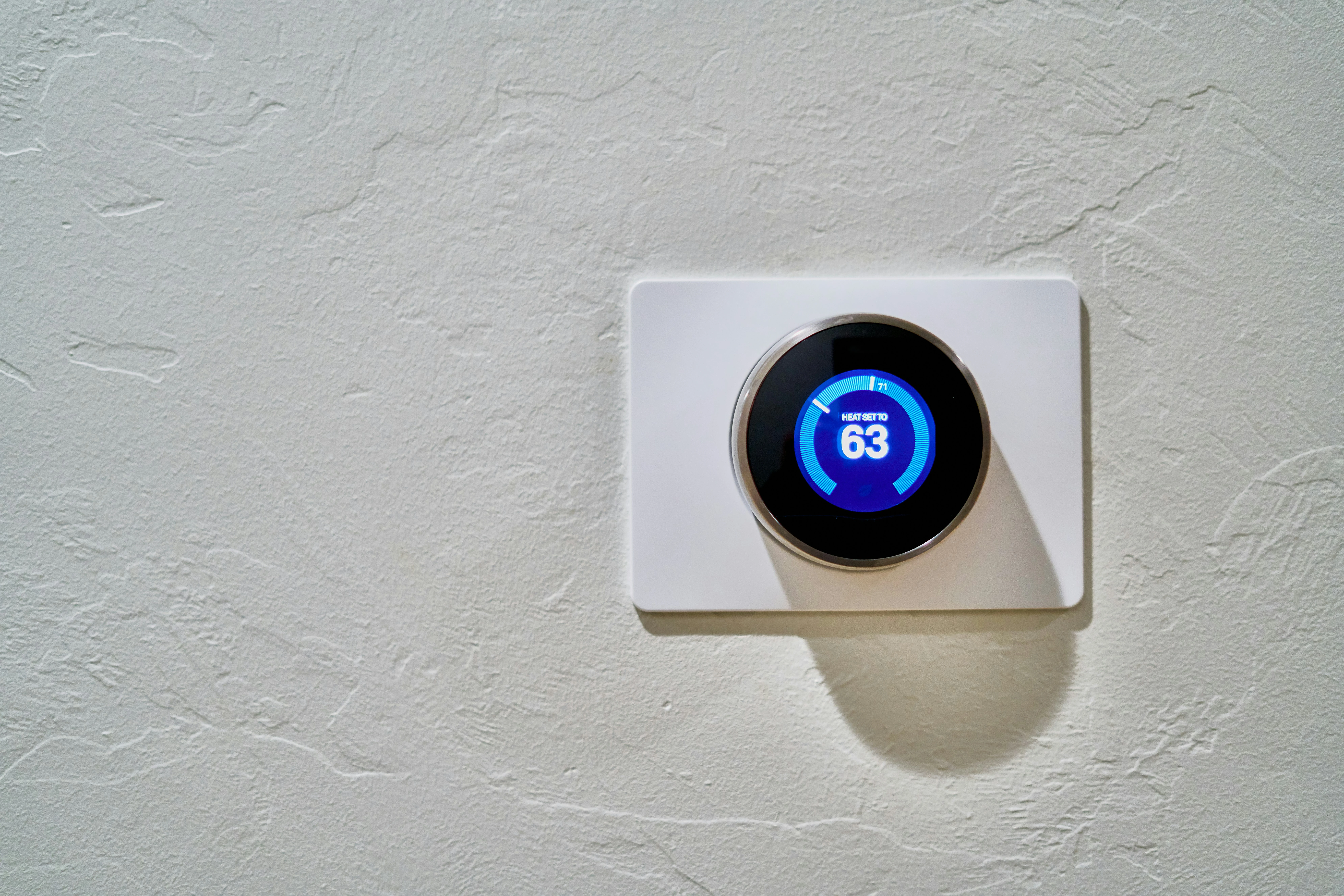 Smart thermostat on a Calgary home wall illustrating energy-saving benefits for homeowners.