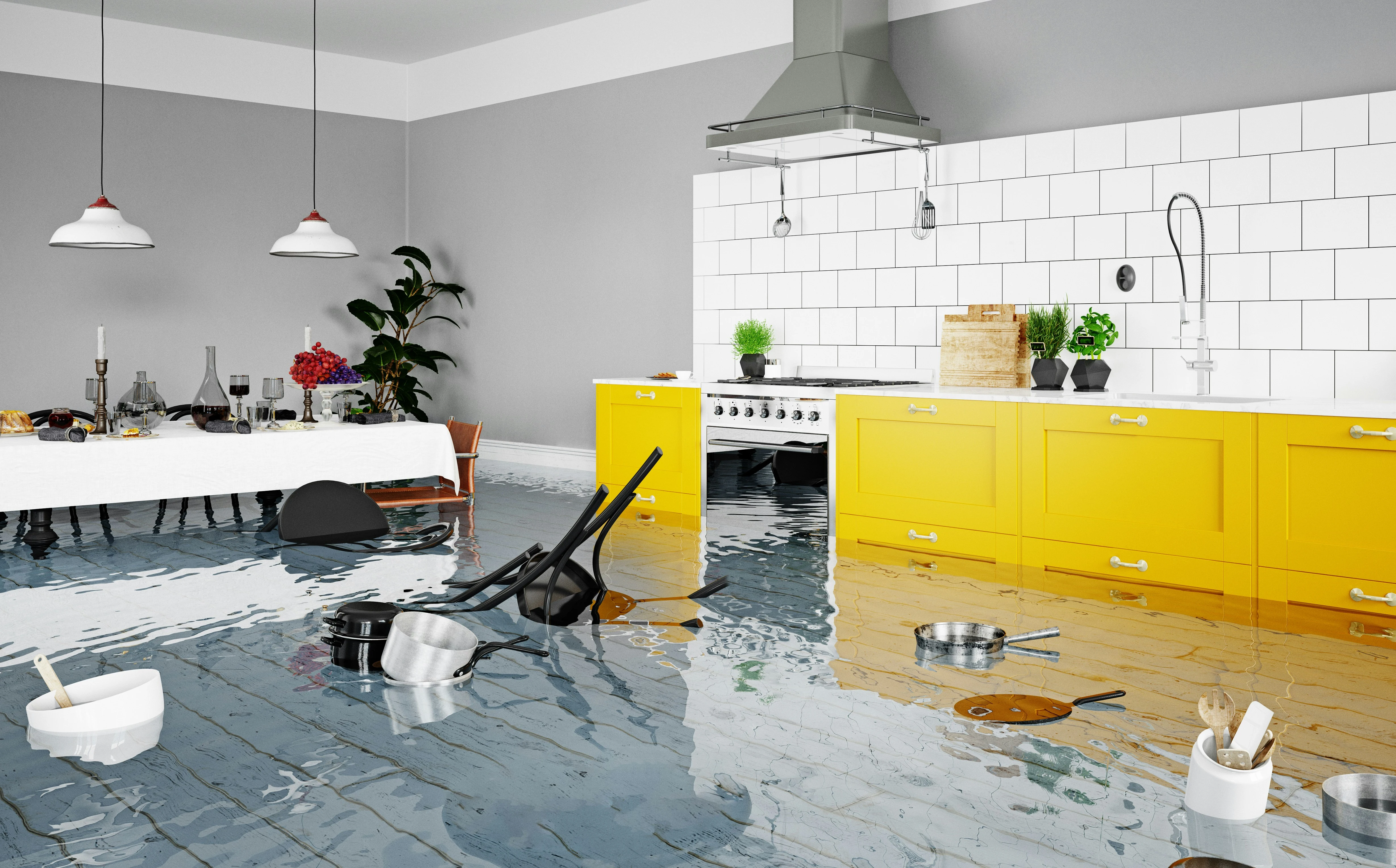 Flooded kitchen with yellow cabinets and floating furniture showing Calgary home water damage.