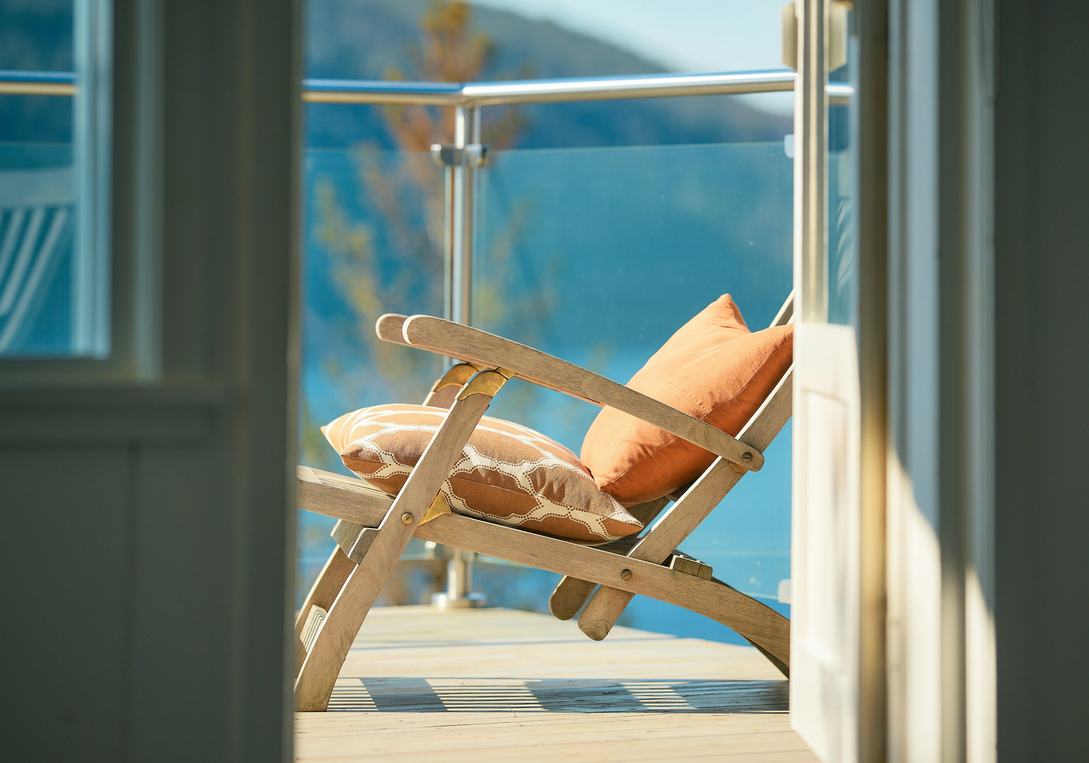 Modern condo balcony with lounge chair and mountain views in Calgary.