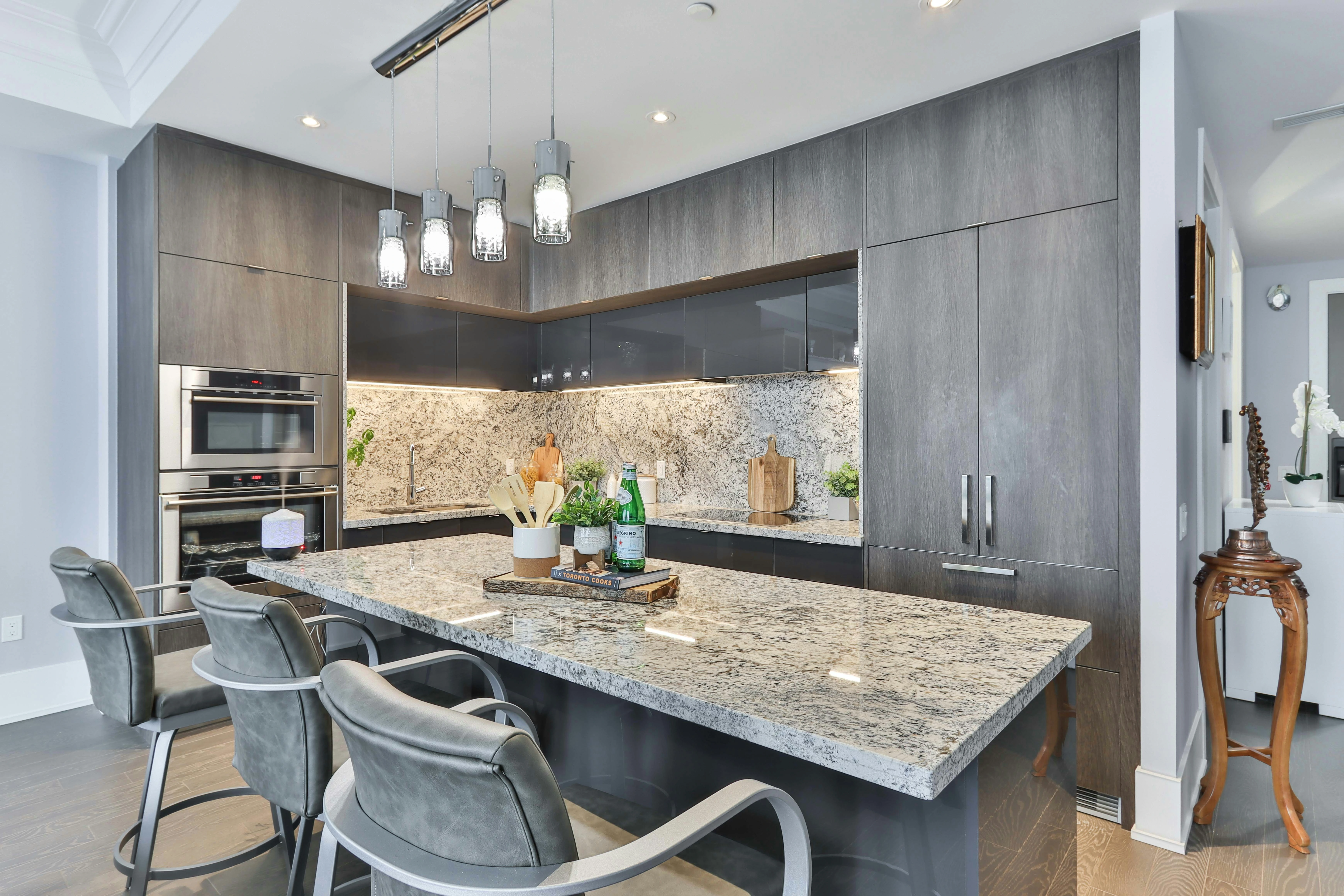 Modern Calgary condo kitchen with granite counters and upgraded appliances, attractive option in buyer’s market.
