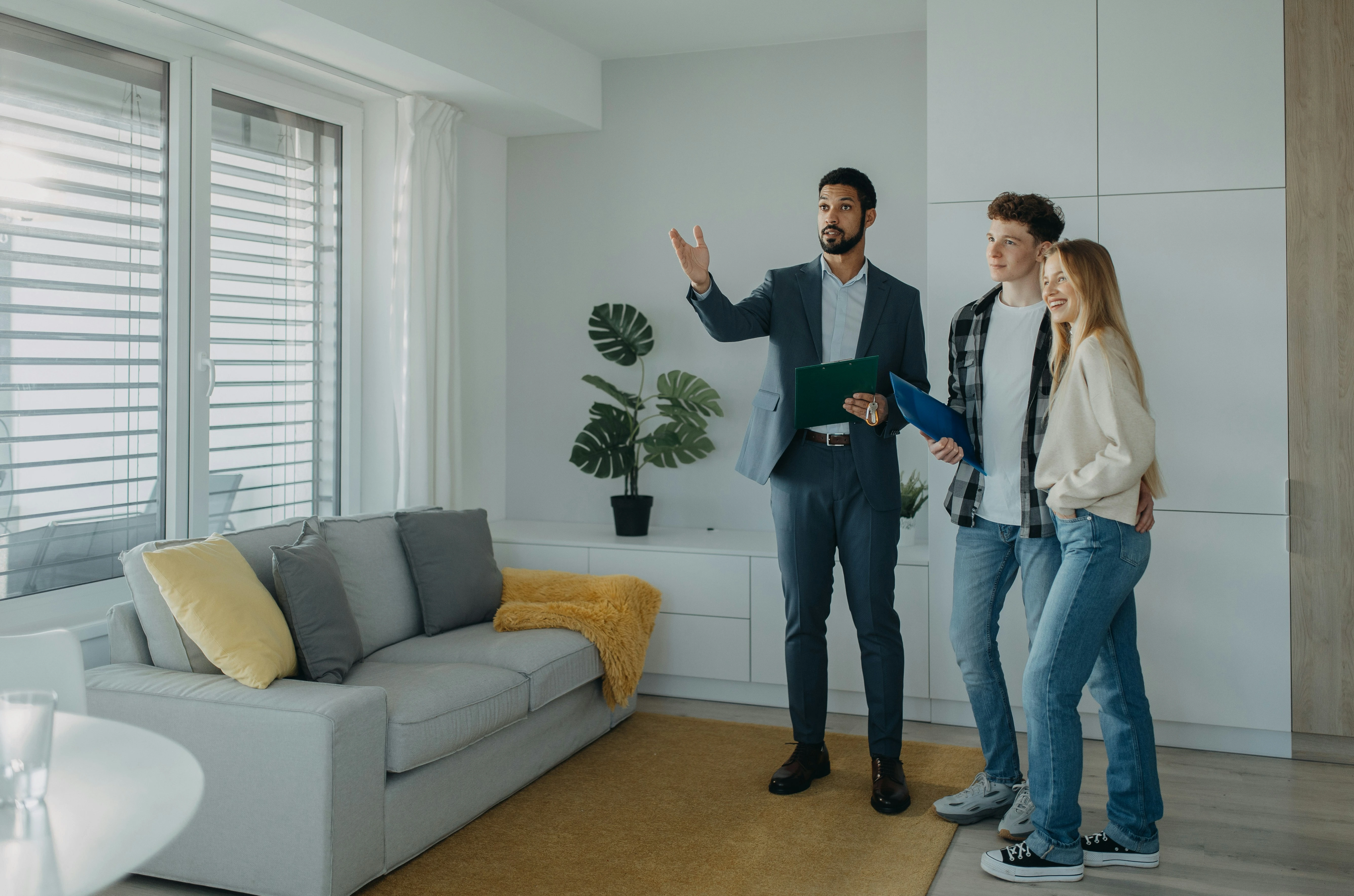 Real estate agent showing a Calgary home to young buyers during property tour in 2025 market.