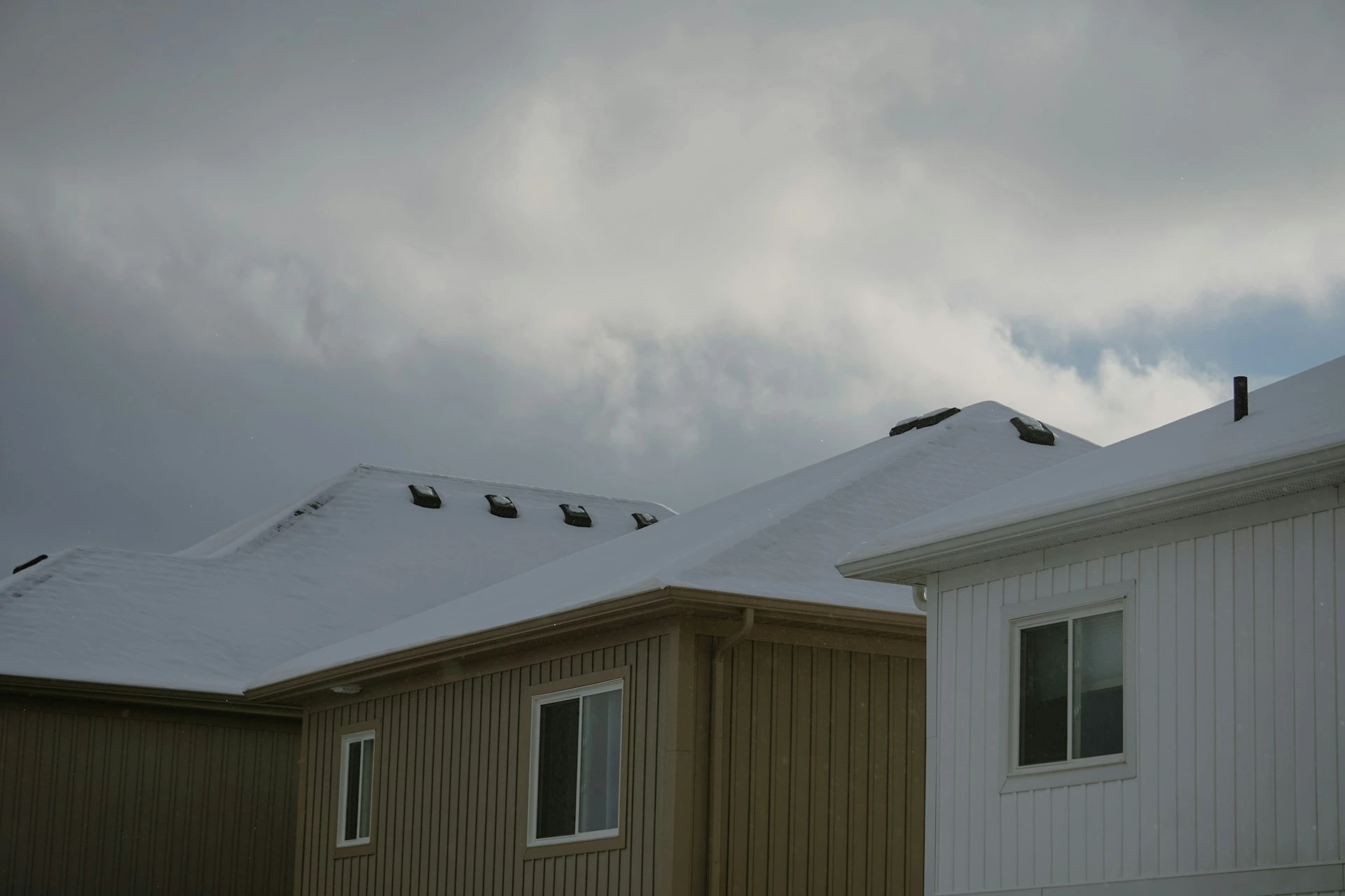 Residential rooftops in Calgary covered with early winter snow.