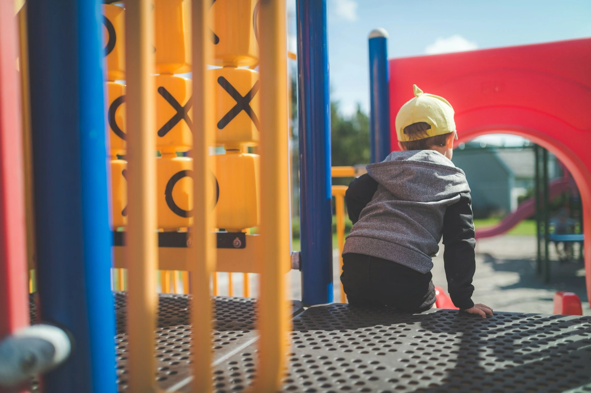 Young child playing on colourful playground equipment in Citadel, Calgary, symbolizing the area&rsquo;s family-friendly atmosphere.