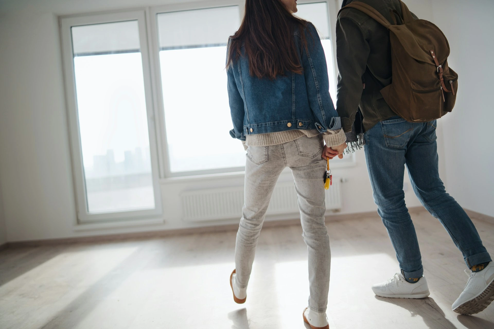 Couple walking through bright Calgary home interior during winter house hunting.