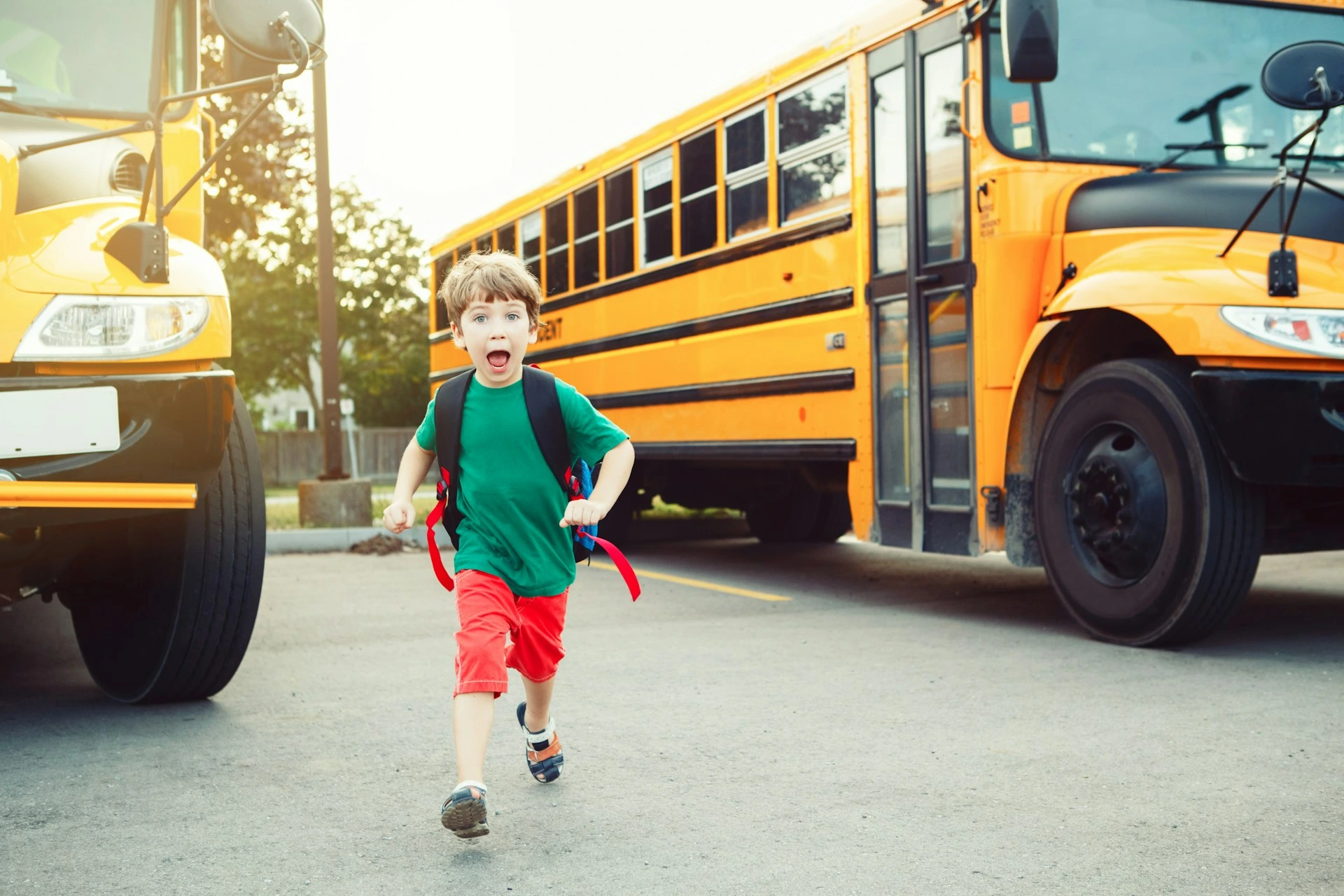Child running near a school bus, symbolizing the family-friendly schools and education options in Dalhousie, Calgary.