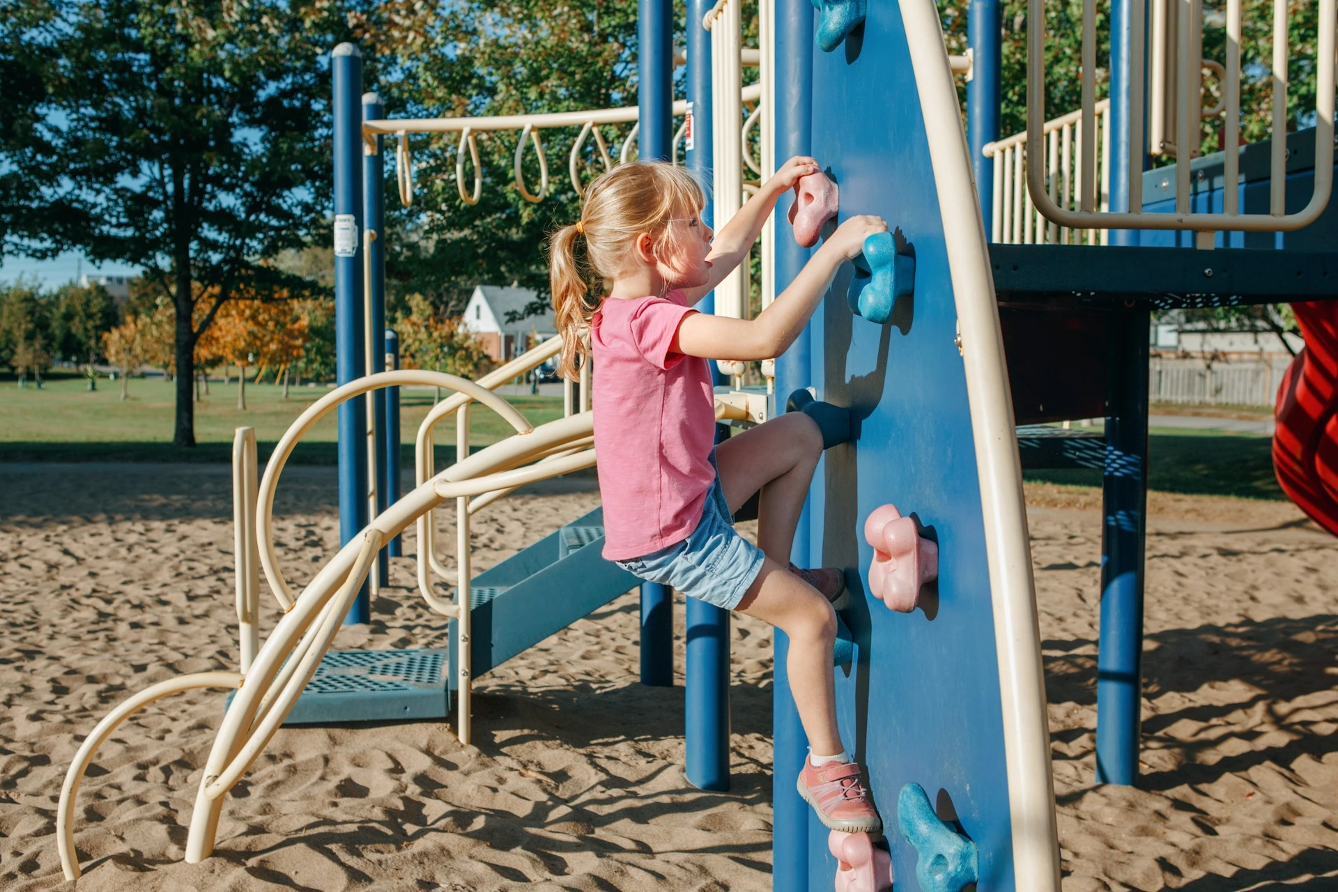 Child climbing at a neighbourhood playground, highlighting Edgemont&rsquo;s parks, pathways, and family-friendly outdoor spaces.