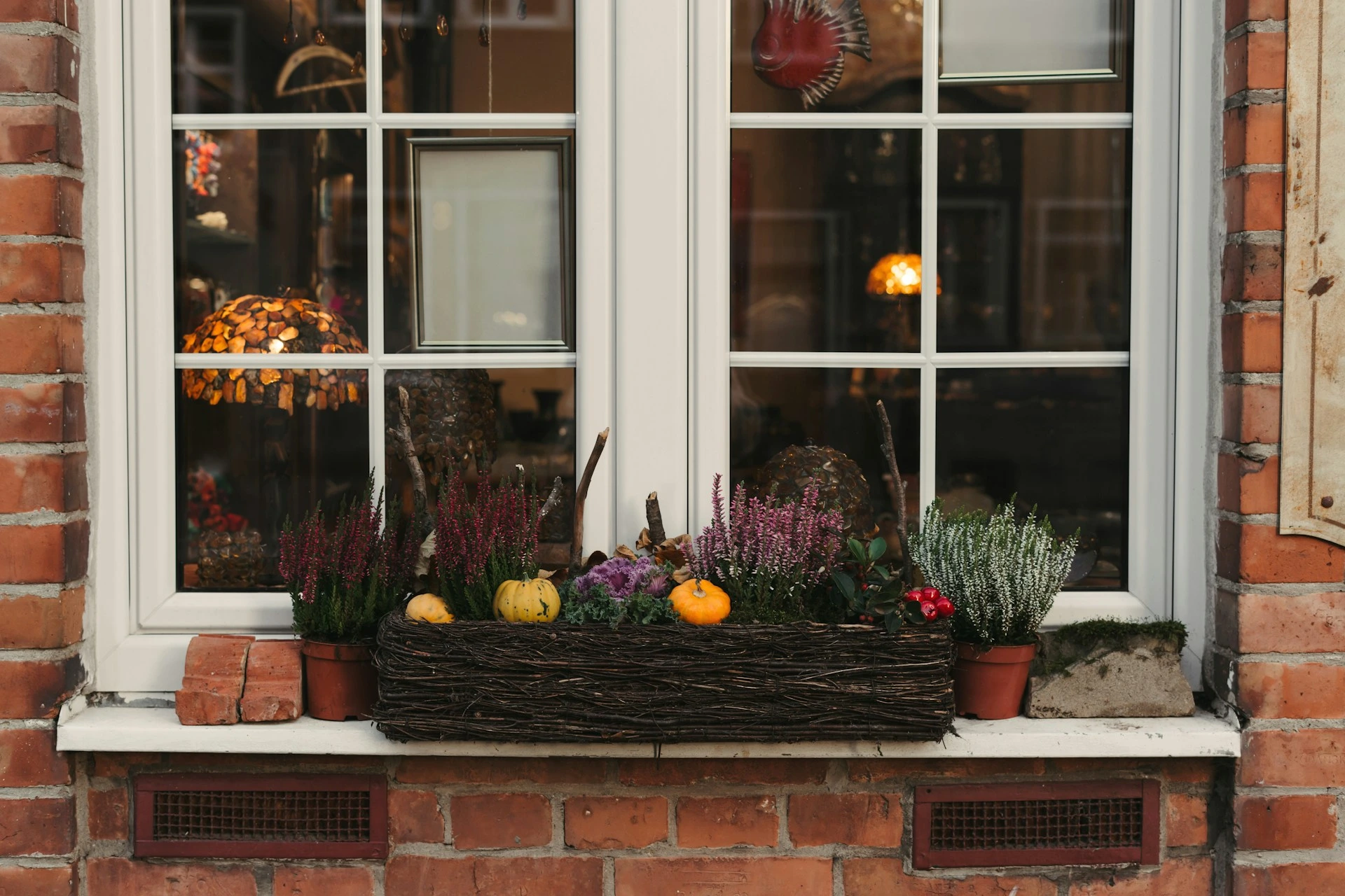 Window planter with fall flowers and pumpkins, enhancing curb appeal for Calgary homes in autumn.