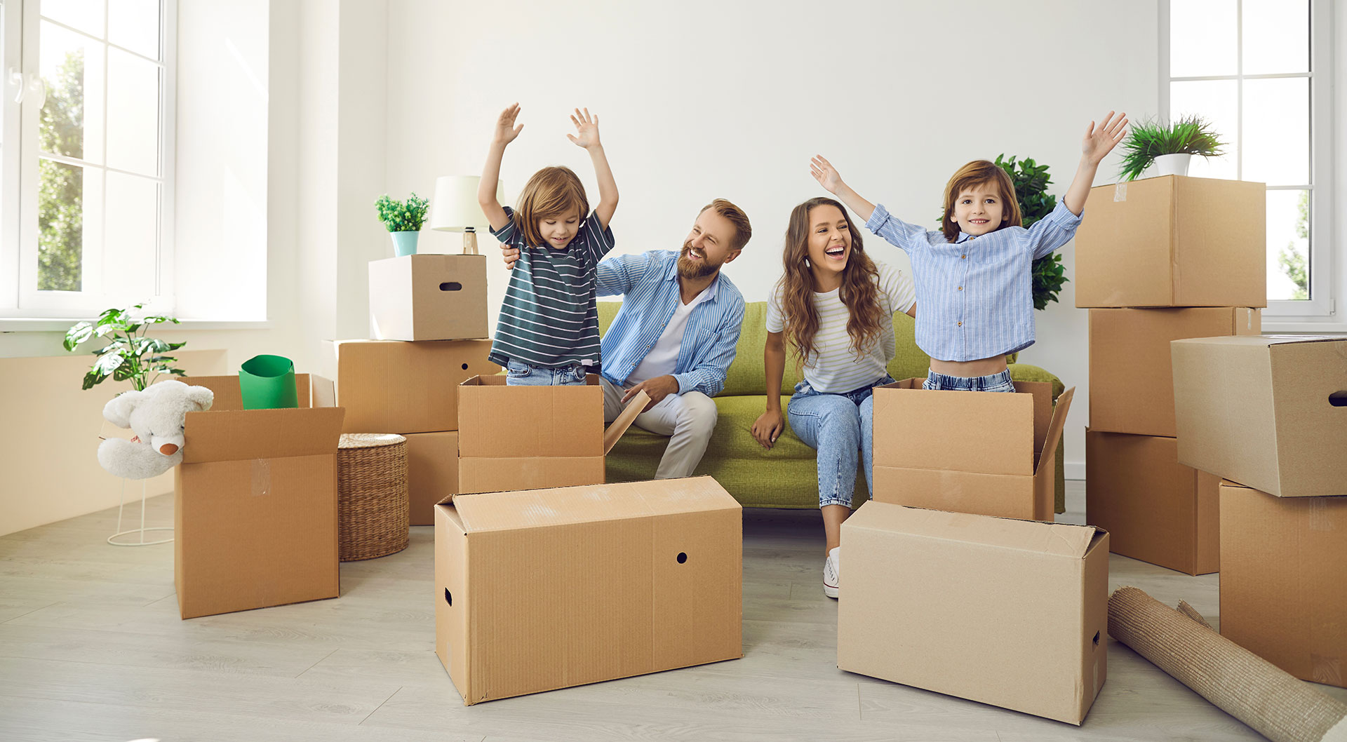 Family moving into a new home in Carrington, northwest Calgary, with moving boxes