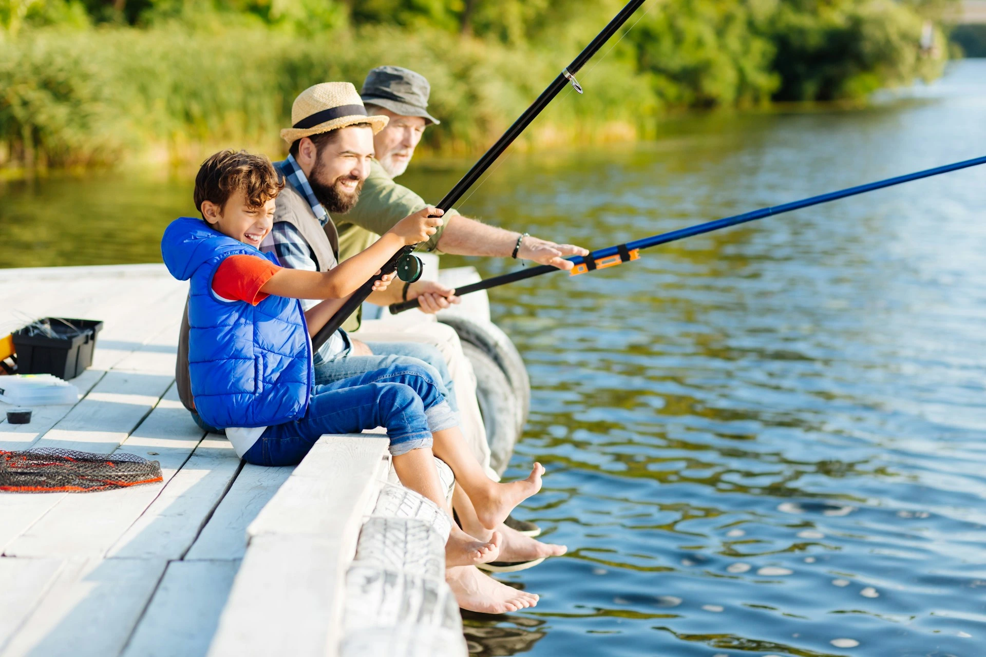 Family fishing together on a dock at Lake Bonavista, representing community and family-friendly lifestyle in Calgary.