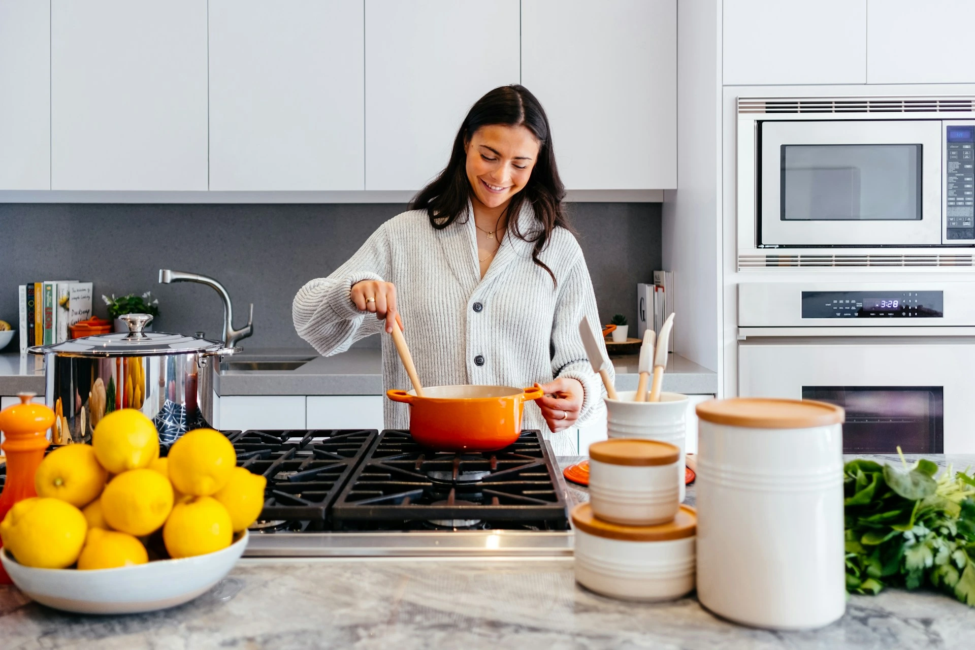 Homeowner cooking in a bright modern kitchen with stylish decor, reflecting home improvements that increase Calgary home value.