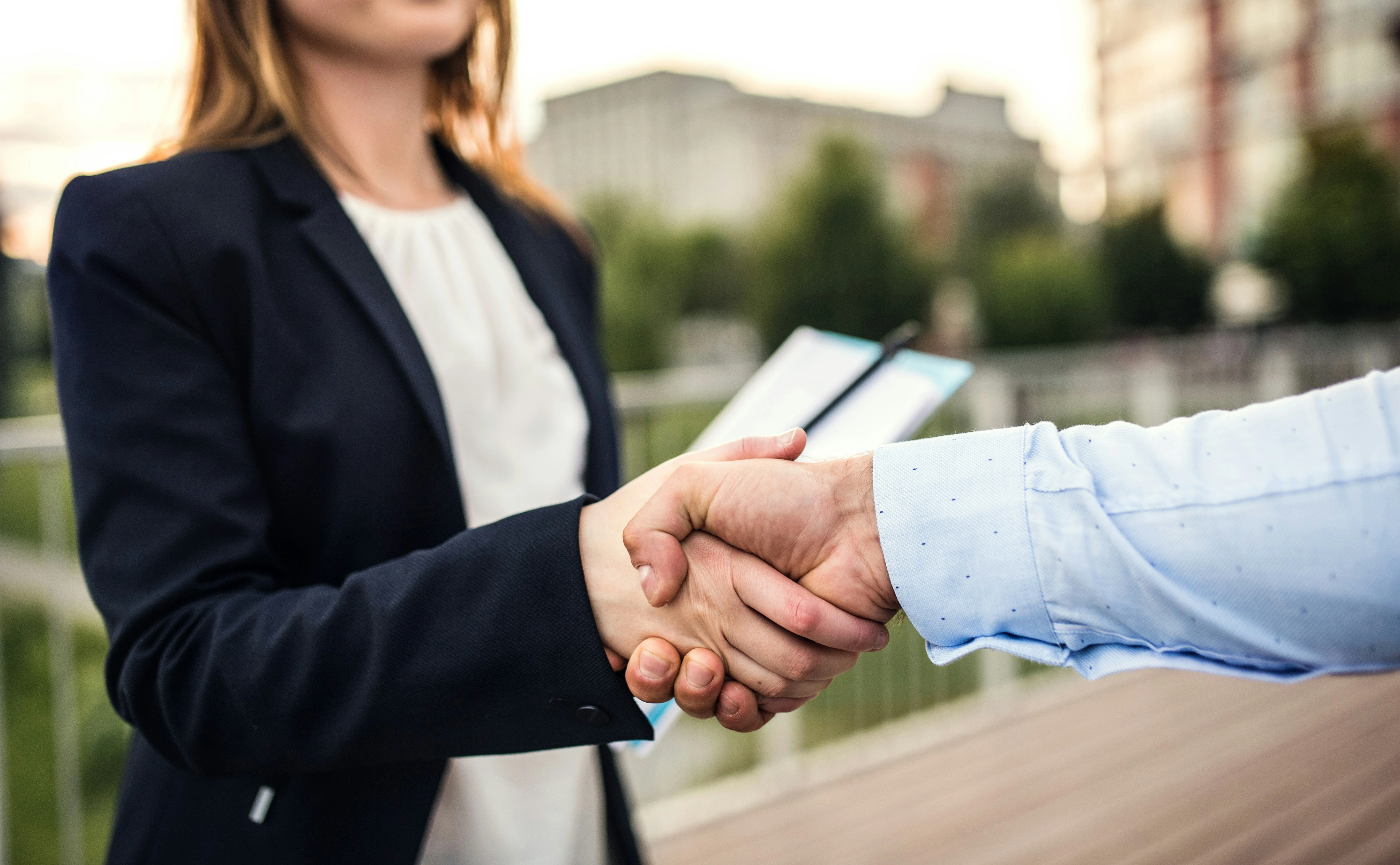 Handshake between real estate agent and client in Calgary, symbolizing trust and successful home sale.