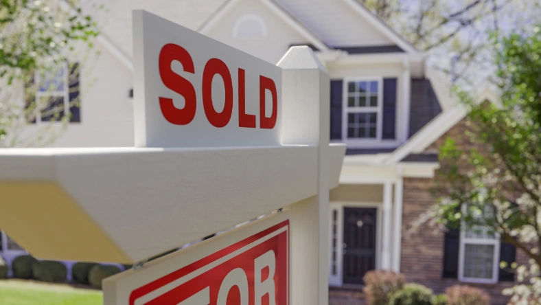 Sold sign in front of a Calgary suburban home — new listings move fast in October 2026