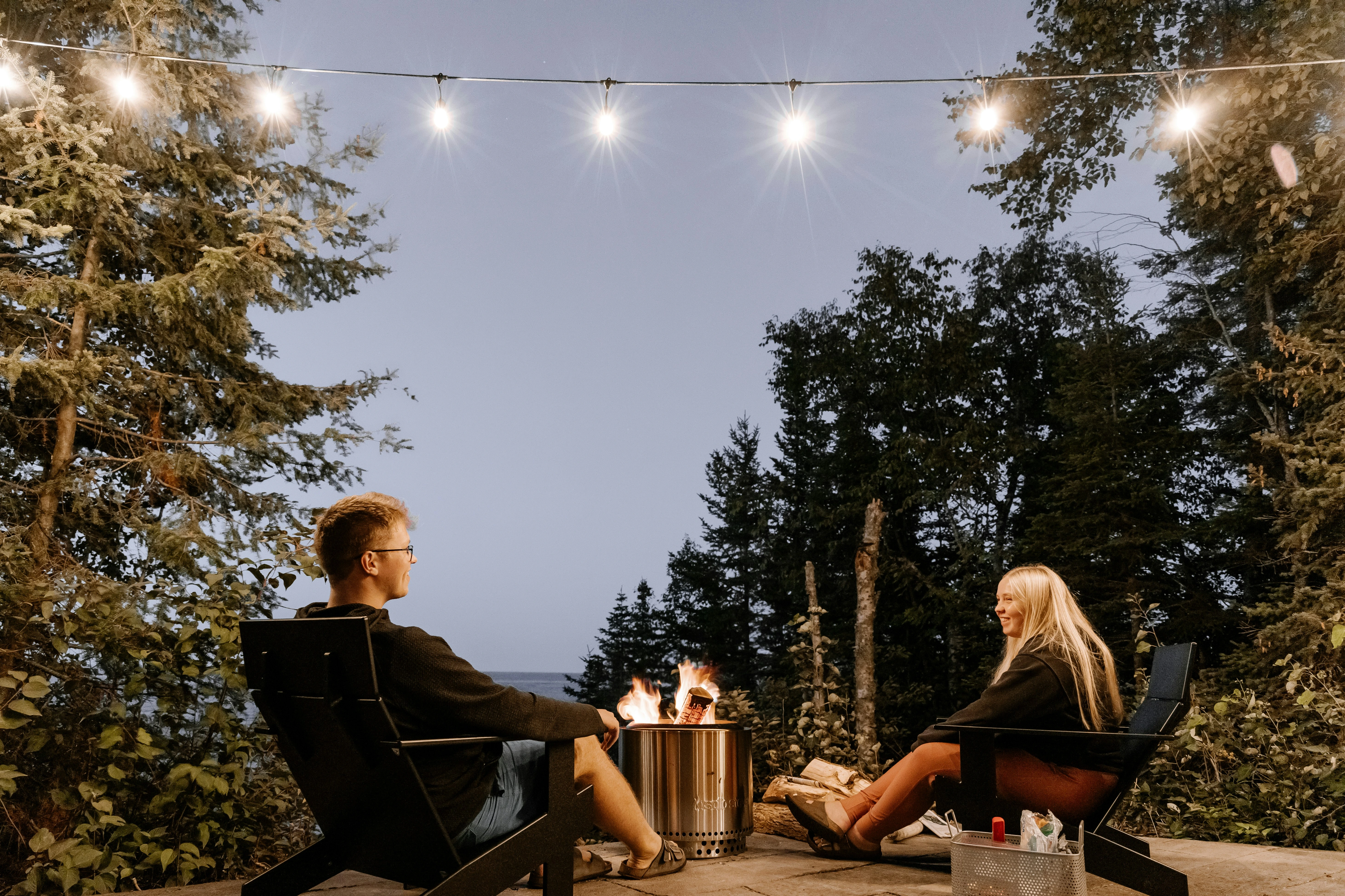 Couple enjoying renovated outdoor living space in Calgary with modern fire pit and patio lights, 2025.