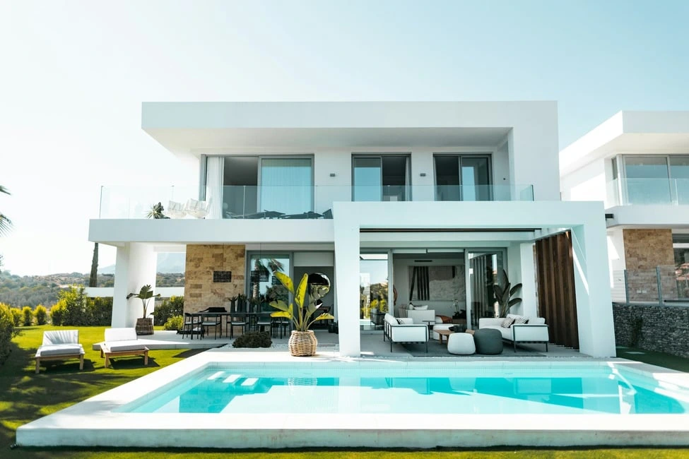 Modern two-story Calgary home with pool and outdoor lounge, representing May 2025 real estate market trends.