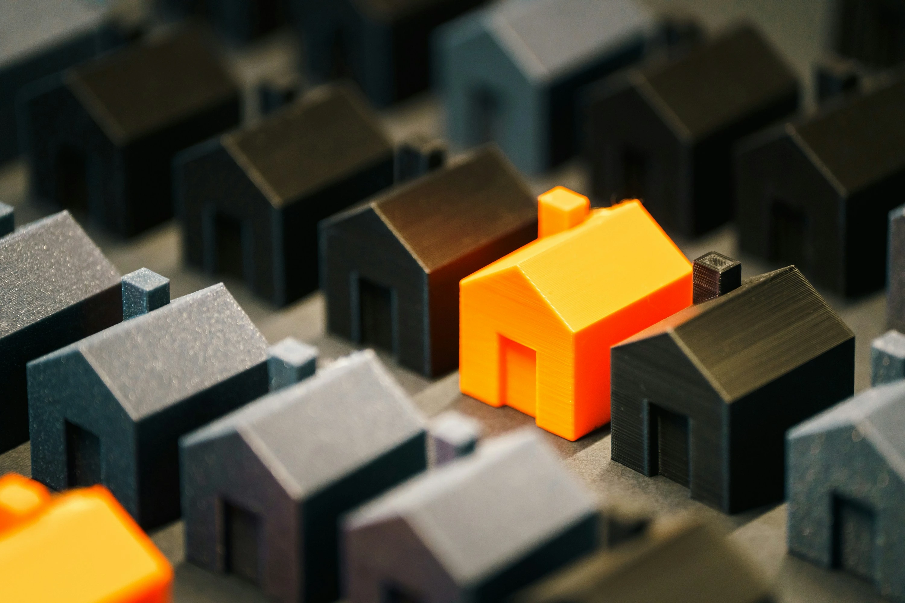 Orange house among dark models symbolizing Calgary housing trends for August 11, 2025 weekly update.