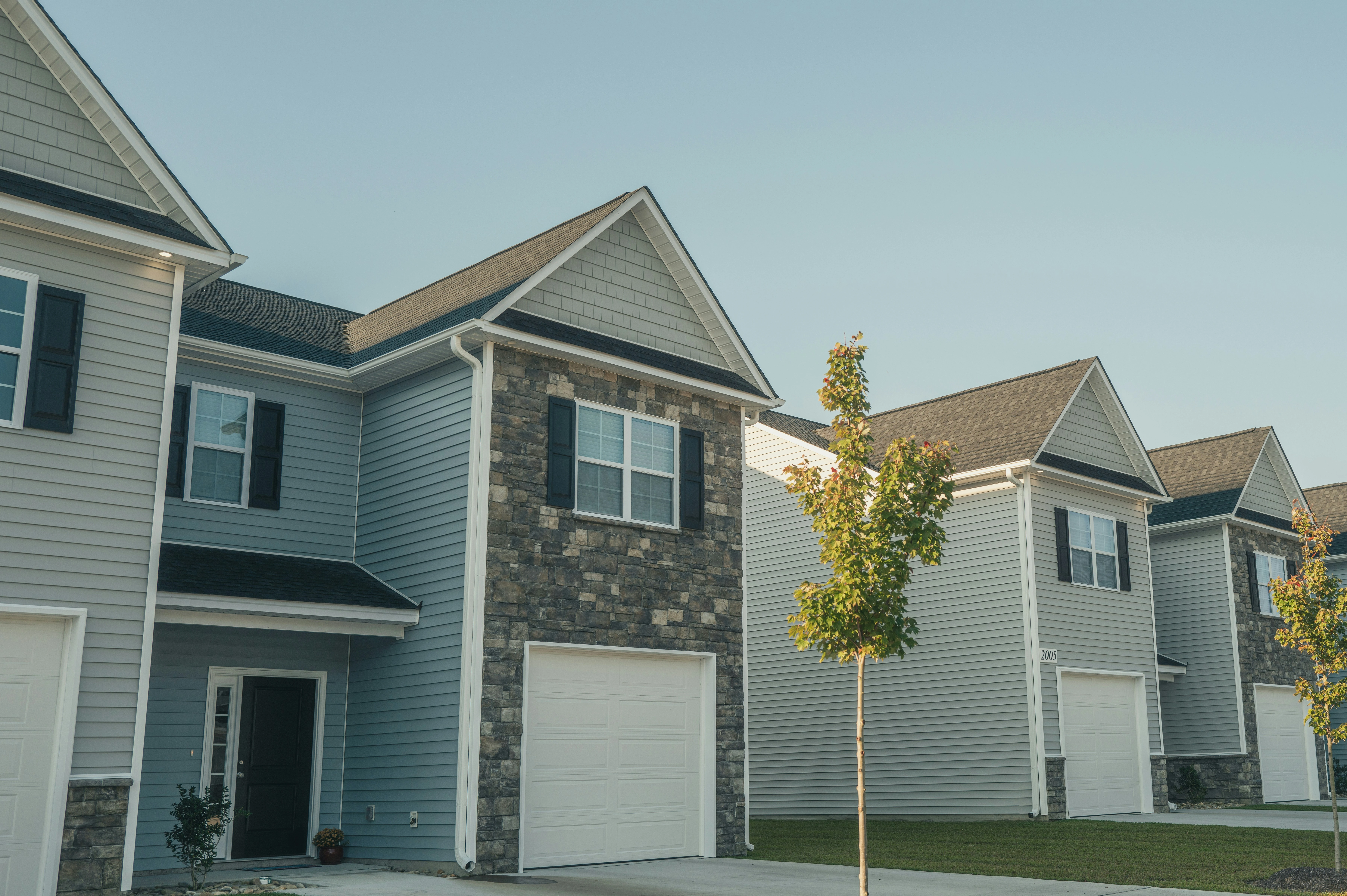 Modern suburban townhomes for sale in Calgary with garages and landscaped driveways.