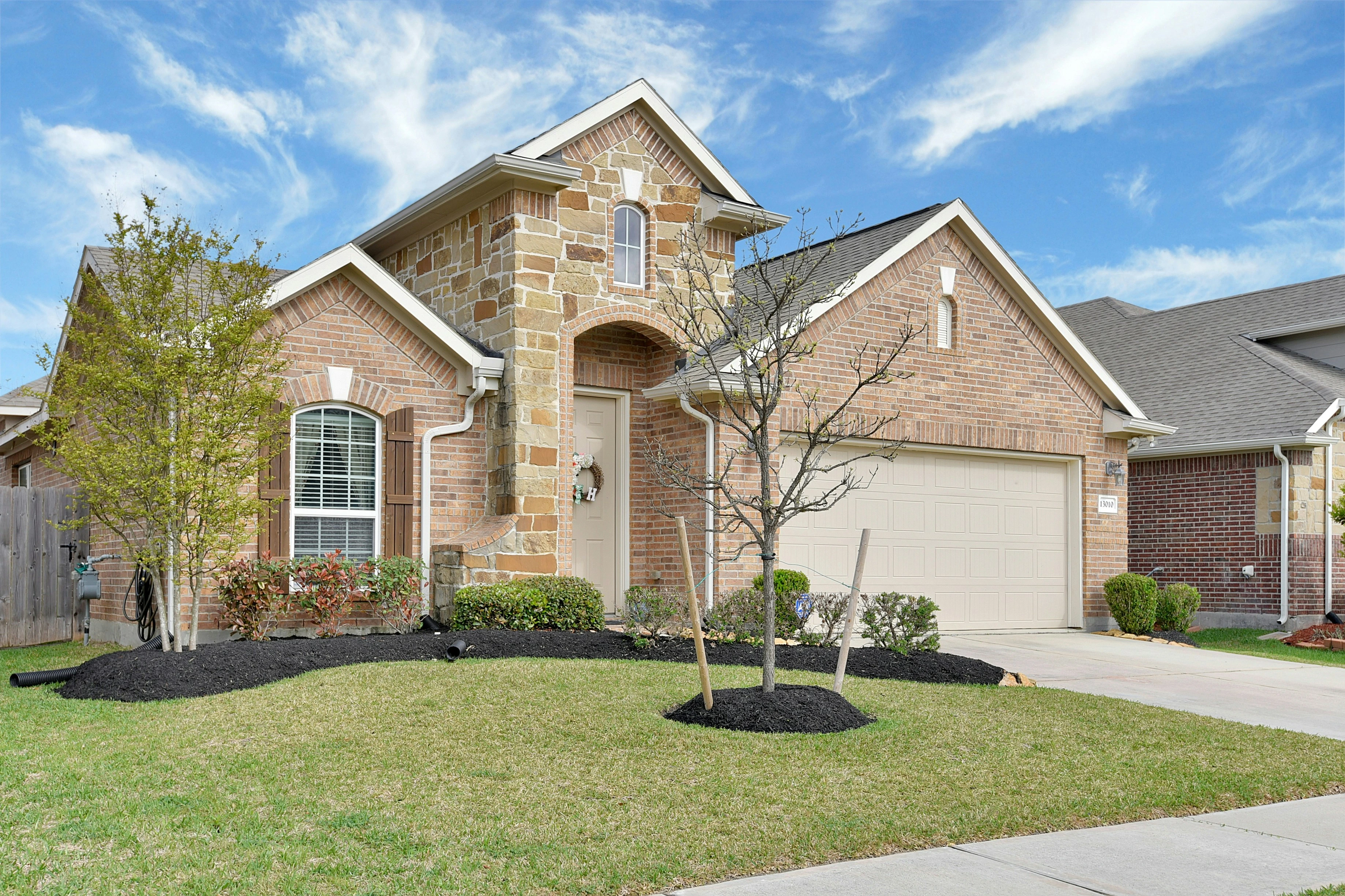 Calgary brick home with front yard and garage, representing land transfer tax and closing costs for buyers.