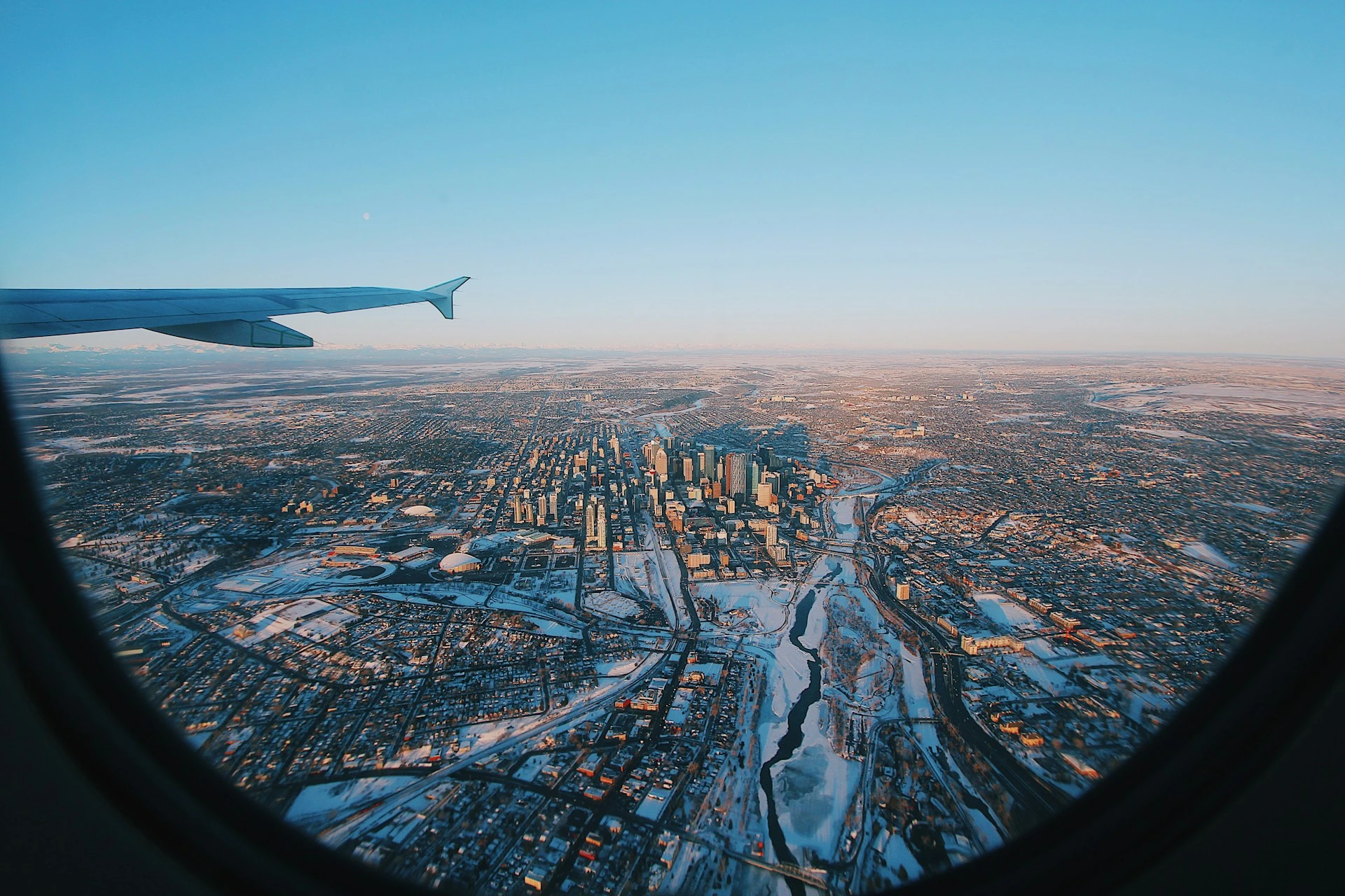 Aerial view of Calgary skyline from airplane window, symbolizing newcomers moving to the city in 2025.